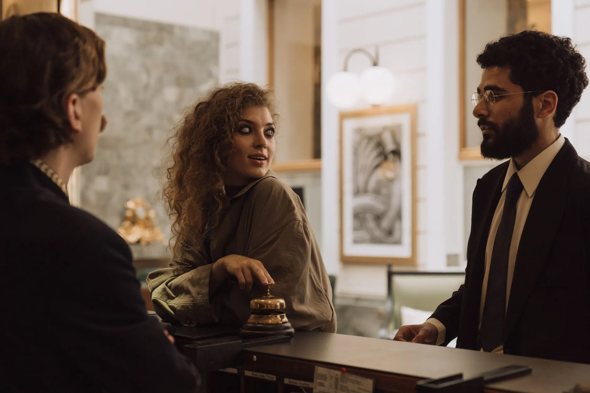 Host u recepce hotelu si povídá s recepcionistou